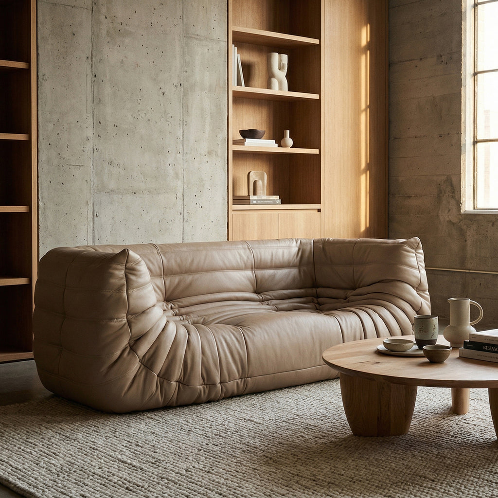 Beige sofa in a modern living room with wooden coffee table and shelves.
