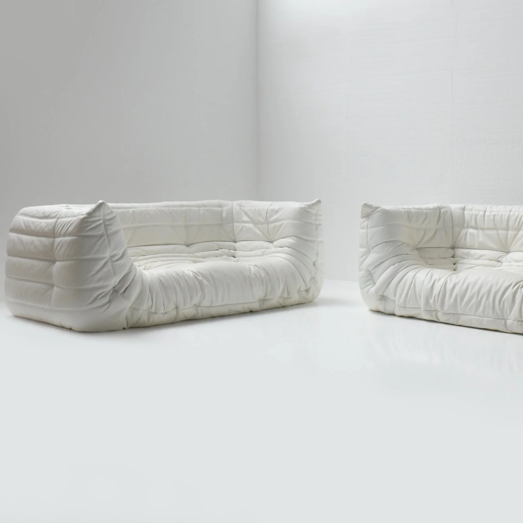 Two white cushioned dog beds on a plain background